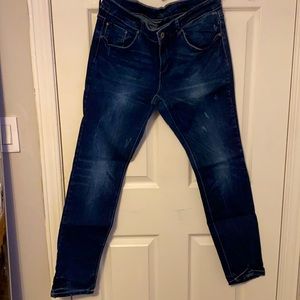 Distressed blue denim jeans